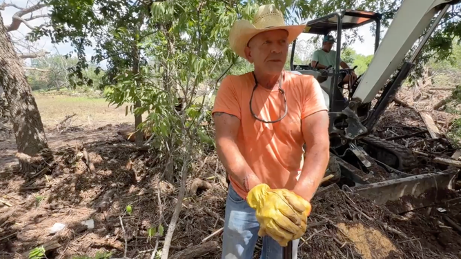 Bud Bolton, of Kerrville, Texas, clearing flooding debris five days after the historic flooding.